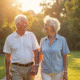 Couple de personnes âgées souriant dans un jardin ensoleille