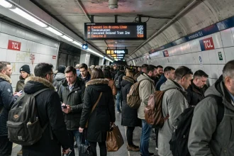 Quai de métro bondé à Lyon lors d'une grève TCL avec des voyageurs frustrés et un tableau d'affichage indiquant des lignes supprimées