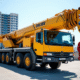 Grue camion jaune sur un chantier urbain en plein jour